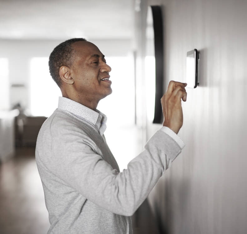 Homme réglant son thermostat – subvention