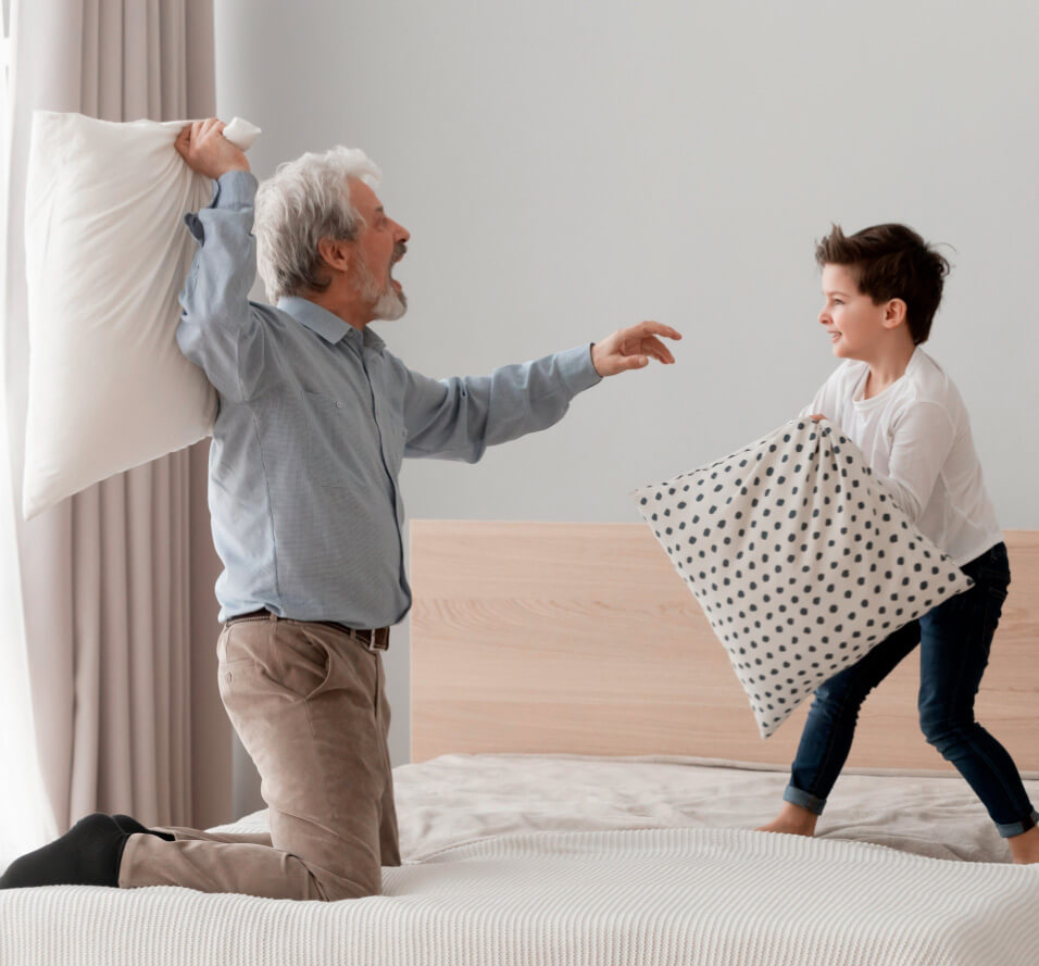 Bataille d’oreillers entre un grand-père et son petit-fils