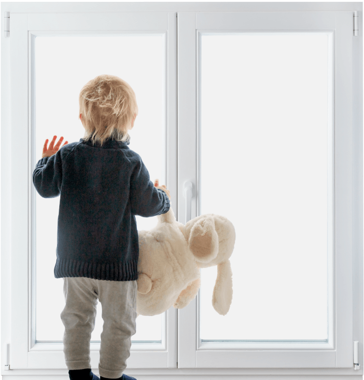 Enfant avec sa peluche regardant par la fenêtre