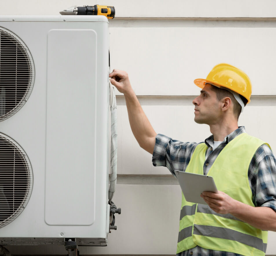 Technicien réparant une thermopompe extérieure