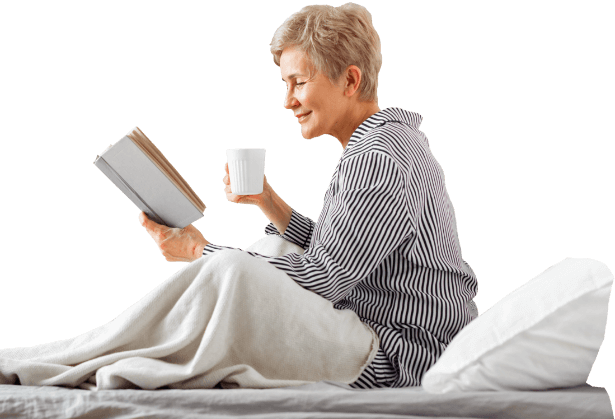 Femme lisant un livre dans son lit bien au chaud
