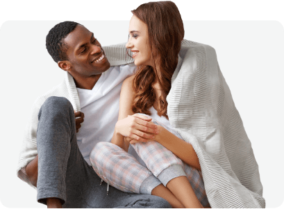 Couple enveloppé dans une couverture profitant du confort à la maison